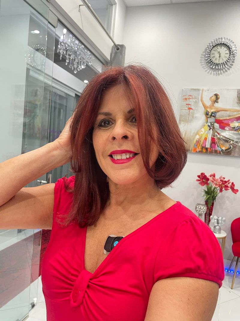 Maria smiling inside her suite at The Lab Salon Suites, showing her copper-red hair